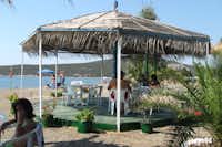 Hydra's Wave Camping - Strand mit Pavillon und Sitzgelegenheiten mit Blick auf das Mittelmeer