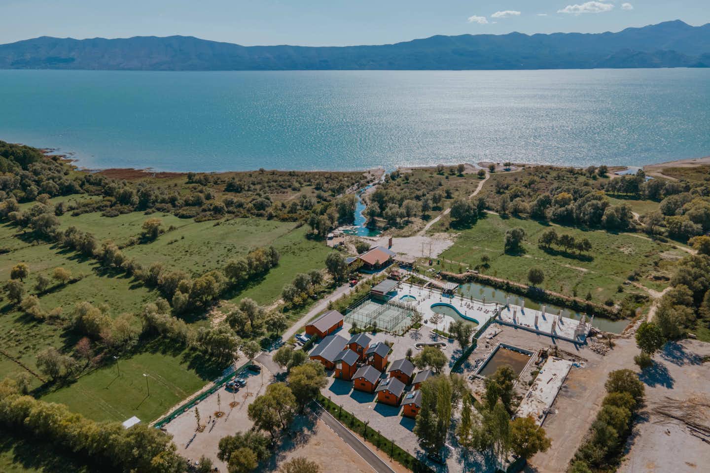 Hysaj Agroturizëm Hotel & Camping  - Luftaufnahme des Campingplatzes am Wasser