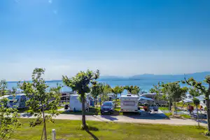 Idea Lazise Camping & Village - Gäste vor ihrem Wohnmobil mit Blick aufs Wasser