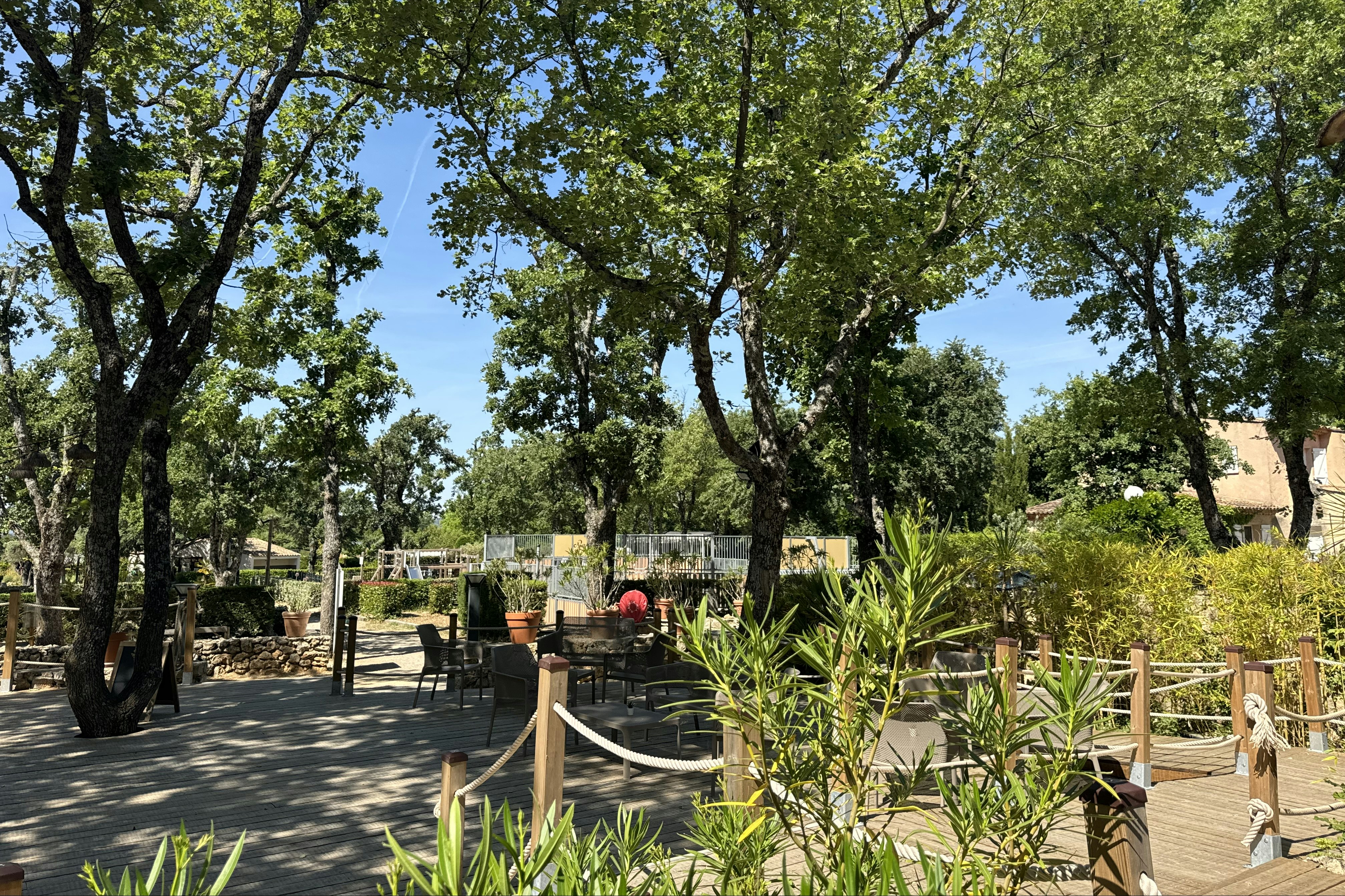 Camping Campasun International d'Aups - Terrassiertes Gelände mit Sitzgelegenheit und Spielplatz im Hintergrund