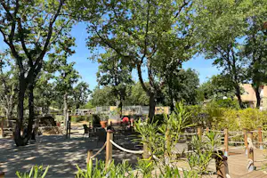 Camping Campasun International d'Aups - Terrassiertes Gelände mit Sitzgelegenheit und Spielplatz im Hintergrund