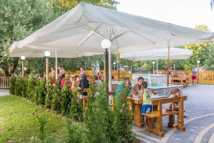 Kamp Slapić - Esstische unter einem Sonnenschirm auf einer Terrasse des Campingplatzes