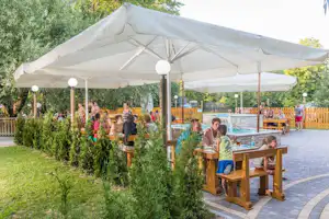 Kamp Slapić - Esstische unter einem Sonnenschirm auf einer Terrasse des Campingplatzes