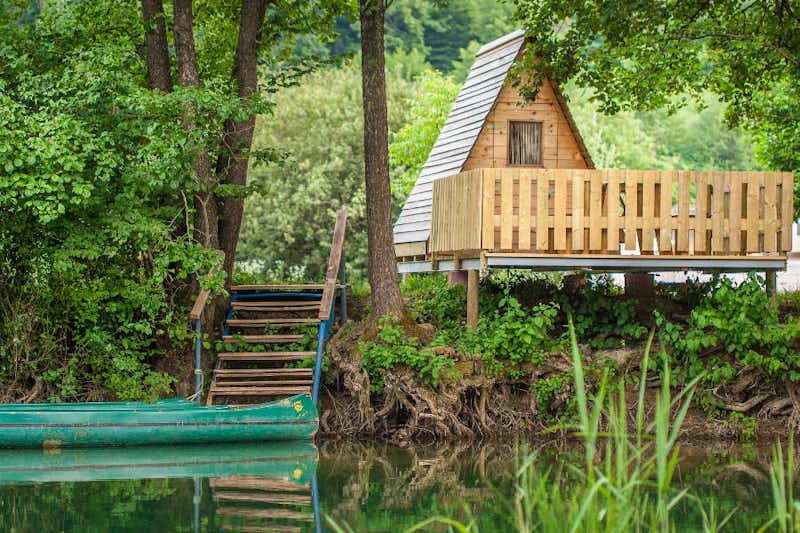 Kamp Slapić - Holzhütte mit Veranda am Ufer des Flusses mit einem angelegten Kajak