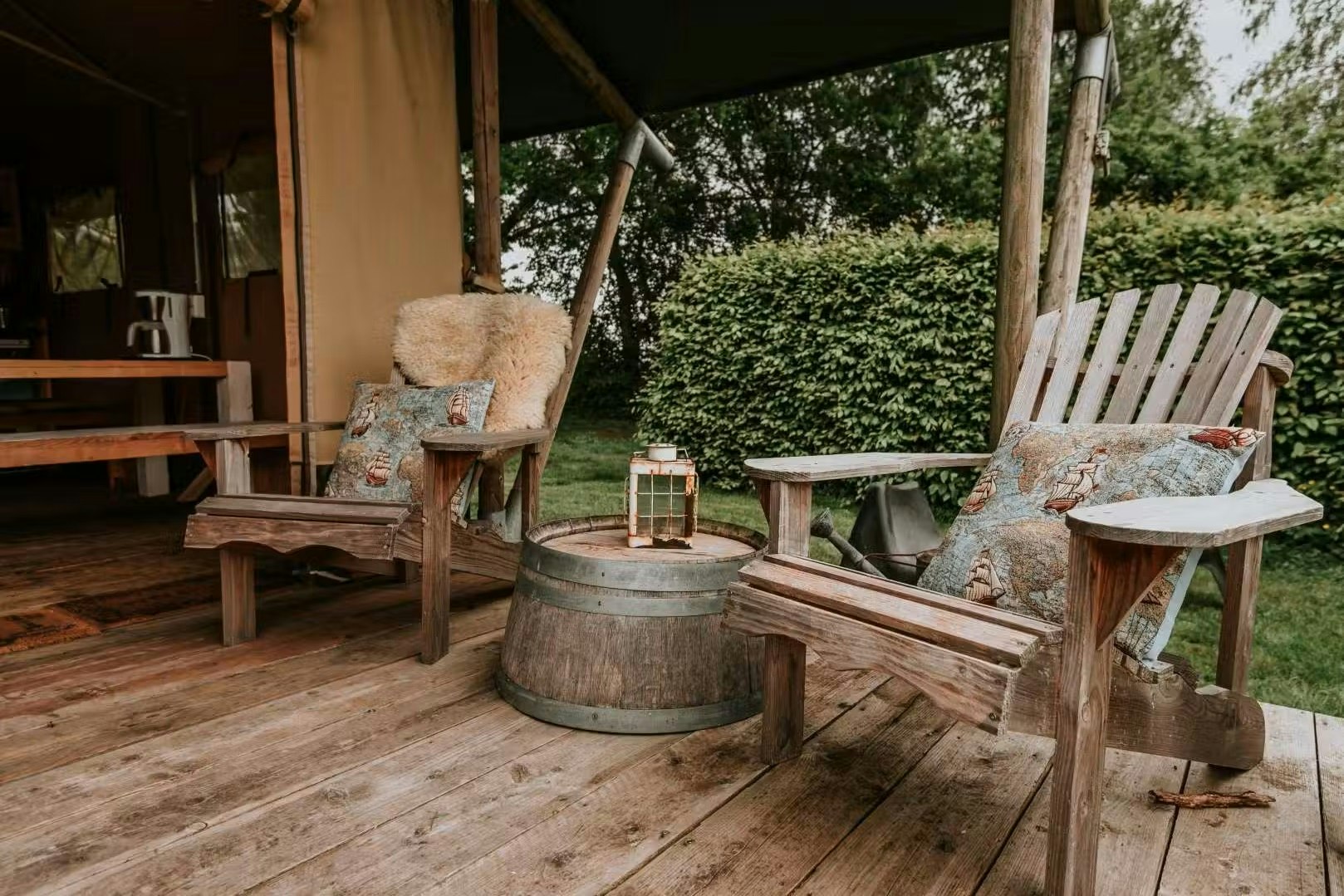 Kampari Safarizelt-Mietunterkunft mit teilweise überdachter Veranda und rustikalen Sitzmöglichkeiten
