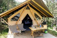 Camping Huttopia De Veluwe - Safarizelt-Mietunterkunft mit überdachter Terrasse und Sitzmöglichkeiten