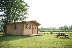 Camping Paberzi - Holzbungalow mit großer Rasenfläche