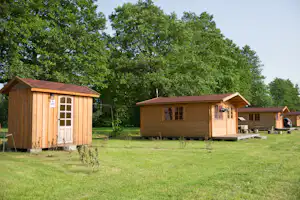 Camping Paberzi - Mobilheime mit großer Rasenfläche und kleinem Toilettengebäude