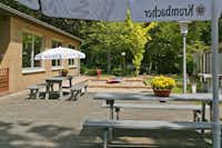 KNAUS Campingpark Elbtalaue/Bleckede - Biergarten mit Bänken und Sonnenschirmen auf dem Campingplatz