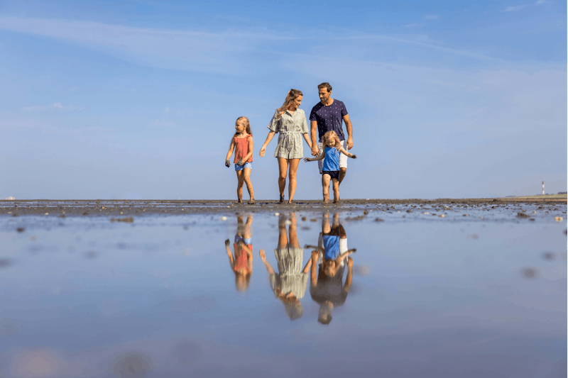 Regenbogen Tossens - Familie beim Spazieren am Strand