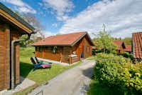 KNAUS Campingpark Viechtach - feststehende Ferienhäuser mit Terrasse an einem gekiesten Fußweg auf einer Wiese