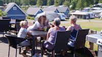 Krakær Camping - Camper sitzen im Restaurant Terrasse  mit Blick auf die  Wohnwagenstellplätze