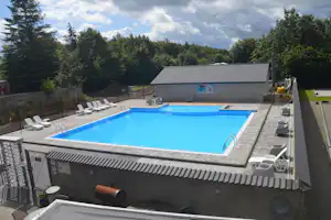 Kruså Camping og Hytter - Pool mit Liegestühlen und Sonnenschirmen auf dem Campingplatz