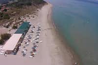 Kum Hotel Camping  -  Luftaufnahme vom Strand am Campingplatz mit Sonnenschirmen und Liegestühlen