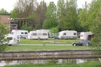 Kumánia Kemping - Grüner Wohnwagenstellplatz am Wasser auf dem Campingplatz