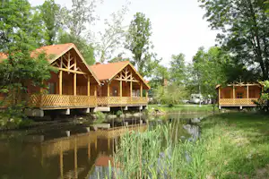 Kumánia Kemping - Mobilheime mit Terrasse mit Blick auf Wasser auf dem Campingplatz