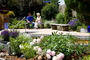 Kur- und Vitalcamping - Wassertretplatz, Blumen und Sitzgelegenheiten auf dem Campinggelände