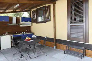 La Timpa International Camping - Mobilheim vom Campingplatz mit Küche und Esstisch auf der Veranda