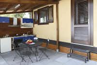 La Timpa International Camping  -  Mobilheim vom Campingplatz mit Küche und Esstisch auf der Veranda
