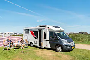 Lakolk Strand Camping - Camper sitzen vor dem Wohnmobil in der Sonne