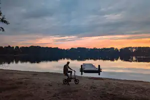 Landschapscamping Het Hazenpad - Blick auf den See mit Badestrand bei Sonnenuntergang