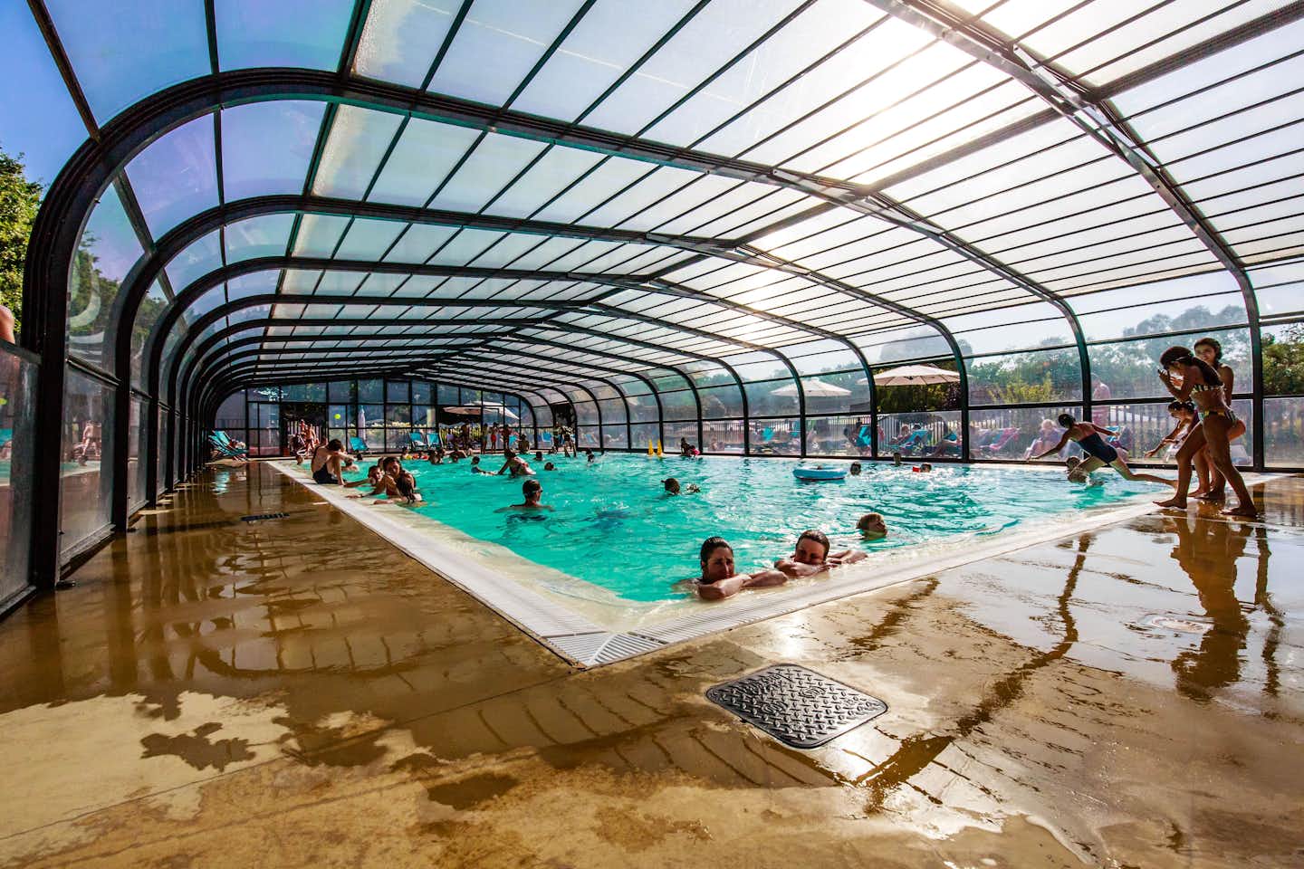Le Domaine de Bréhadour - Gäste und Kinder schwimmen im Pool in der Glashalle 