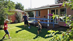 Le Hameau des Genêts - Kinder spielen Fußball auf der Wiese vor einem Mobilheim