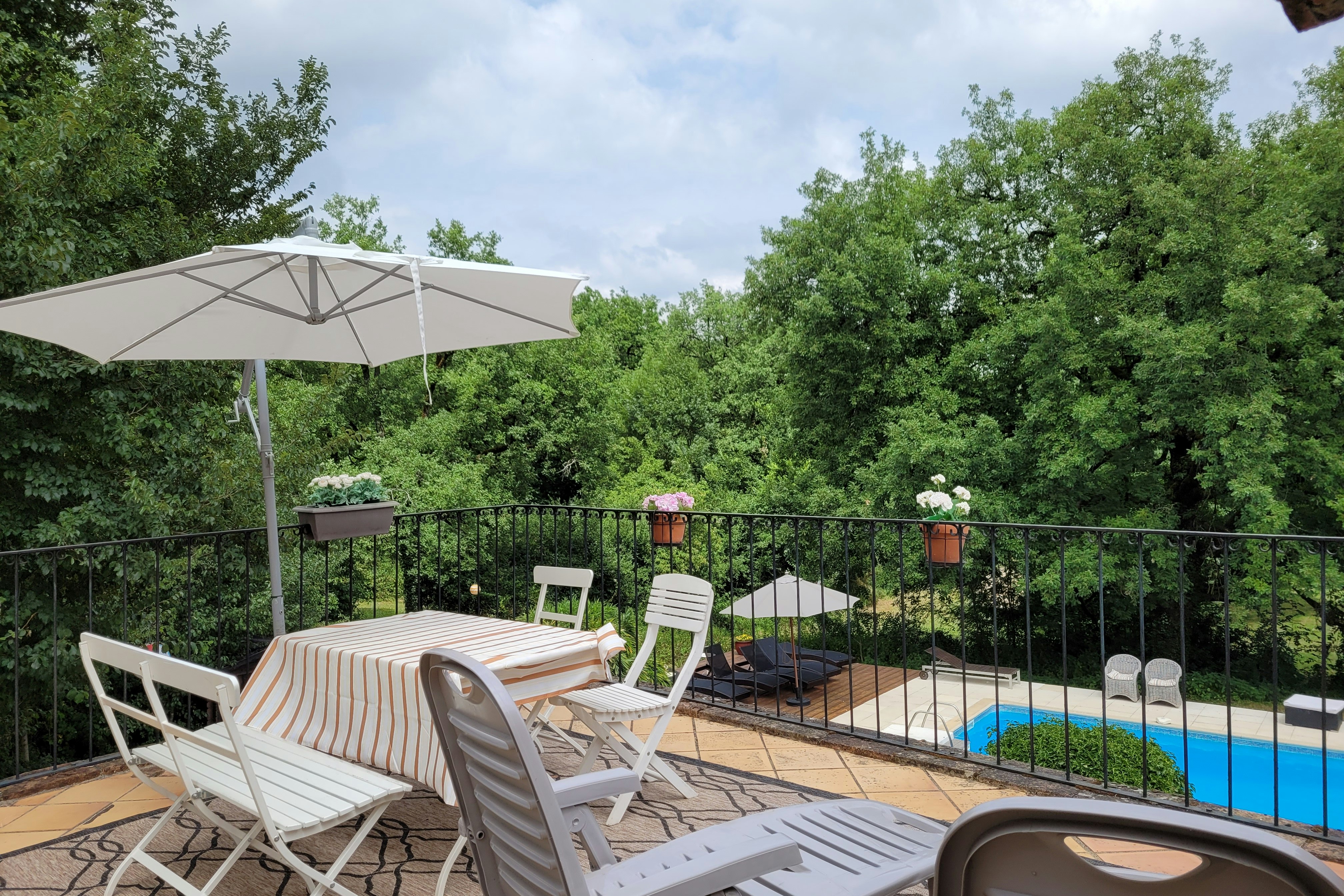 Le Mas du Midi - Terrasse eines Ferienapartments mit Blick auf den Pool auf dem Campingplatz