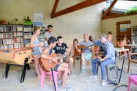 Le Vieux Colombier - Gitarrenstunde im Gemeinschaftsraum mit Büchern, Tischfußball und Spielen