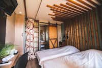 Le Village de Cottages - Schlafzimmer mit zwei Einzelbetten in einem Mobilheim