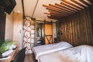 Le Village de Cottages - Schlafzimmer mit zwei Einzelbetten in einem Mobilheim