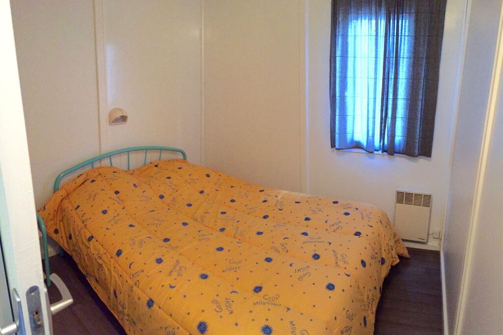 Le Village des Sources - Schlafzimmer mit Doppelbett in einem Mobilheim