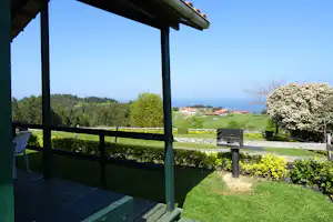 Leagi Camping - Mobilheim vom Campingplatz mit Grill an der Veranda und Blick auf den Atlantischen Ozean