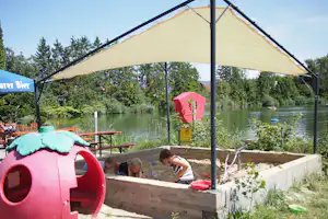 Lech Camping - Spielplatz vom Campingplatz mit Sandkasten und Blick auf den See