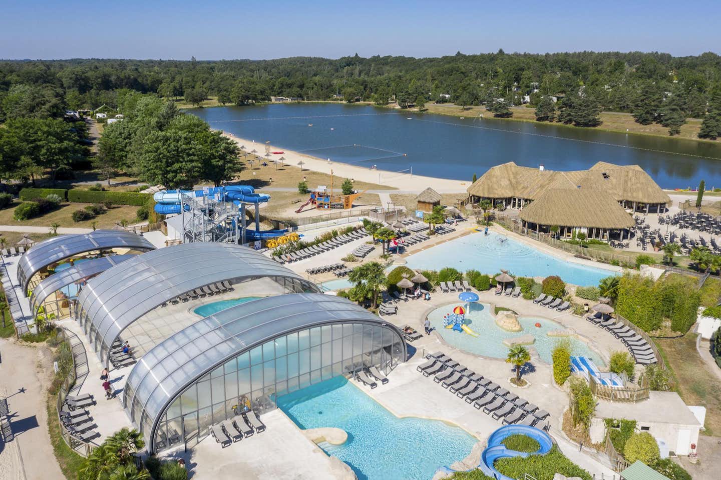 Les Alicourts Resort - Übersicht auf das gesamte Campingplatz Gelände: Pool, Wasserrutsche, Liegestühlen und Sonnenschirmen
