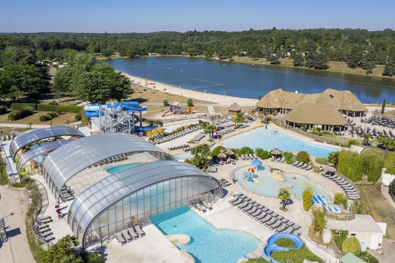Les Alicourts Resort - Übersicht auf das gesamte Campingplatz Gelände: Pool, Wasserrutsche, Liegestühlen und Sonnenschirmen