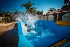 Les Jardins catalans - Kind auf der Wasserrutsche im Poolbereich vom Campingplatz