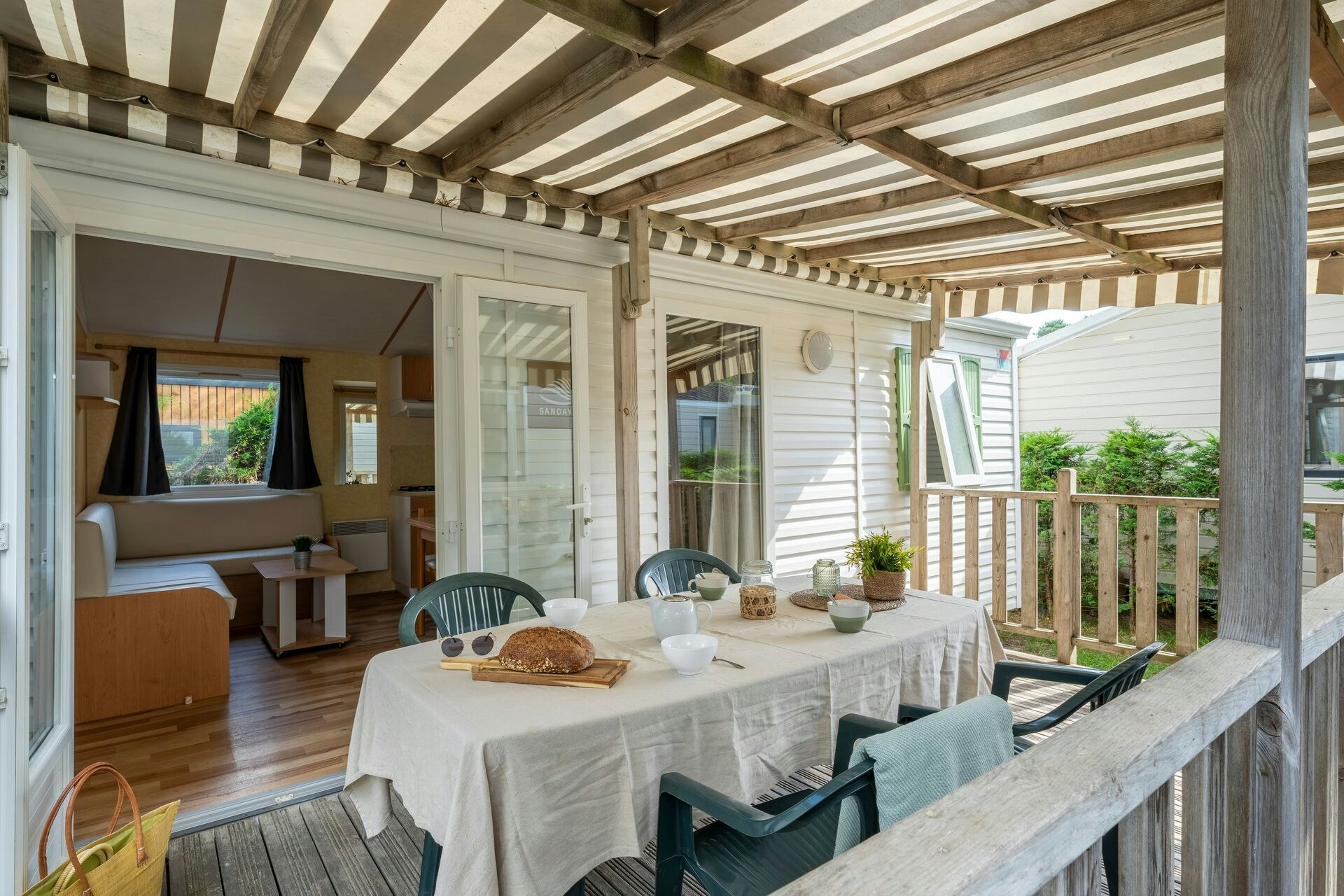 Camping Sandaya L'Estanquet - Tisch auf der Veranda des Mobilheims mit Blick nach innen