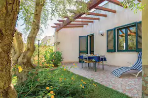 Lilybeo Village - Wohngarten mit Liegestühlen und Esstisch