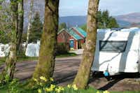 Linnhe Lochside Holidays - ohnwagenstellplätze und Sanitärgebäude zwischen den Bäumen auf dem Campingplatz