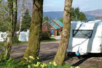 Linnhe Lochside Holidays - ohnwagenstellplätze und Sanitärgebäude zwischen den Bäumen auf dem Campingplatz