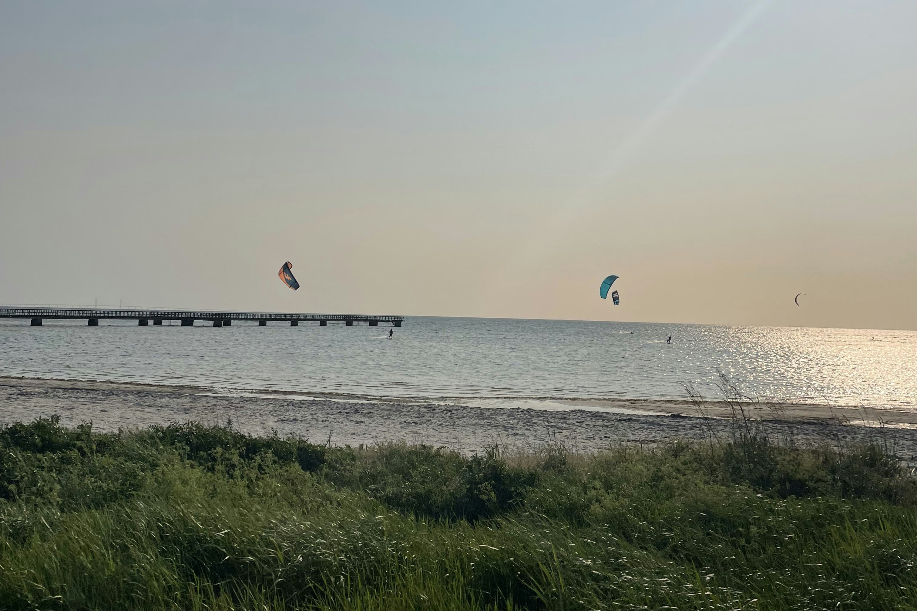 Lomma Camping & Resort -  Blick auf das Meer mit Badesteg und Kitesurfern
