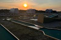 Lomma Camping & Resort - Minigolfanlage mit Blick auf die Standplätze bei Sonnenuntergag