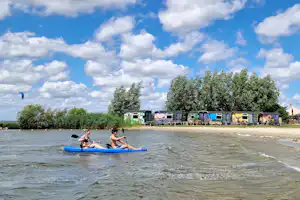 Marina Parcs - Camper auf Stand-Up-Paddelboard am Strand am Campingplatz
