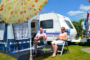 Marveld Recreatie - Camper sitzen vor dem Wohnmobil im Schatten der Markise