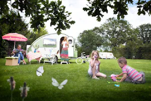 Marveld Recreatie - Familie sitzen vor dem Wohnmobil