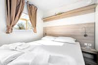 Mediteran Kamp @ Camping Ulika Naturist - Schlafzimmer mit Doppelbett und Fenster zur Veranda in einer Mietunterkunft