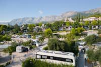Medora Orbis Camping & Glamping - Blick auf die Standplätze auf dem Campingplatz mit Bergen im Hintergrund