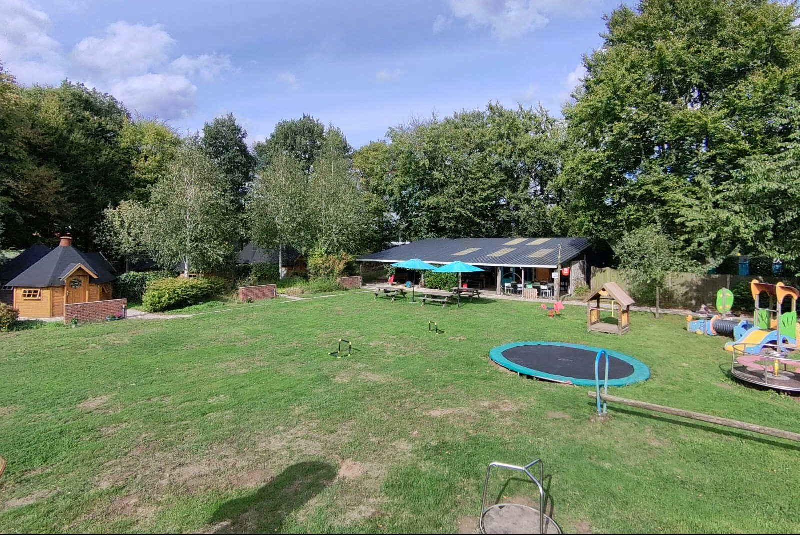 Buitengoed Holthees  Minicamping Buitenboel Bij ons4 - Blick auf den Campingplatz mit Kinderspielplatz und Trampolin