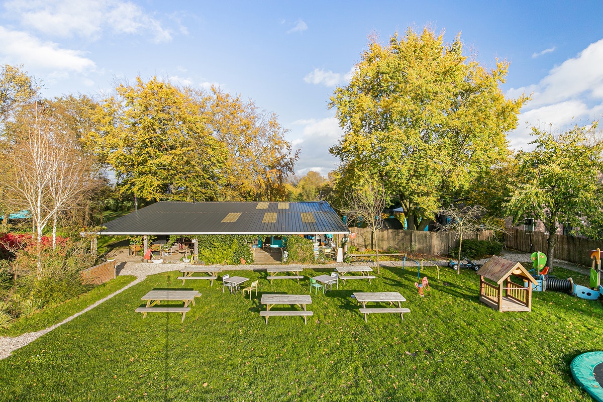 Buitengoed Holthees  Minicamping Buitenboel Bij ons4 - Terrasse mit Picknickbänken und Kinderspielgeräten